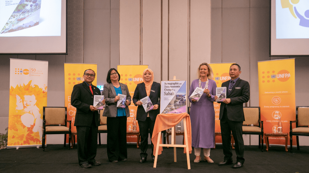 A group of representatives launch the report pose for a photo